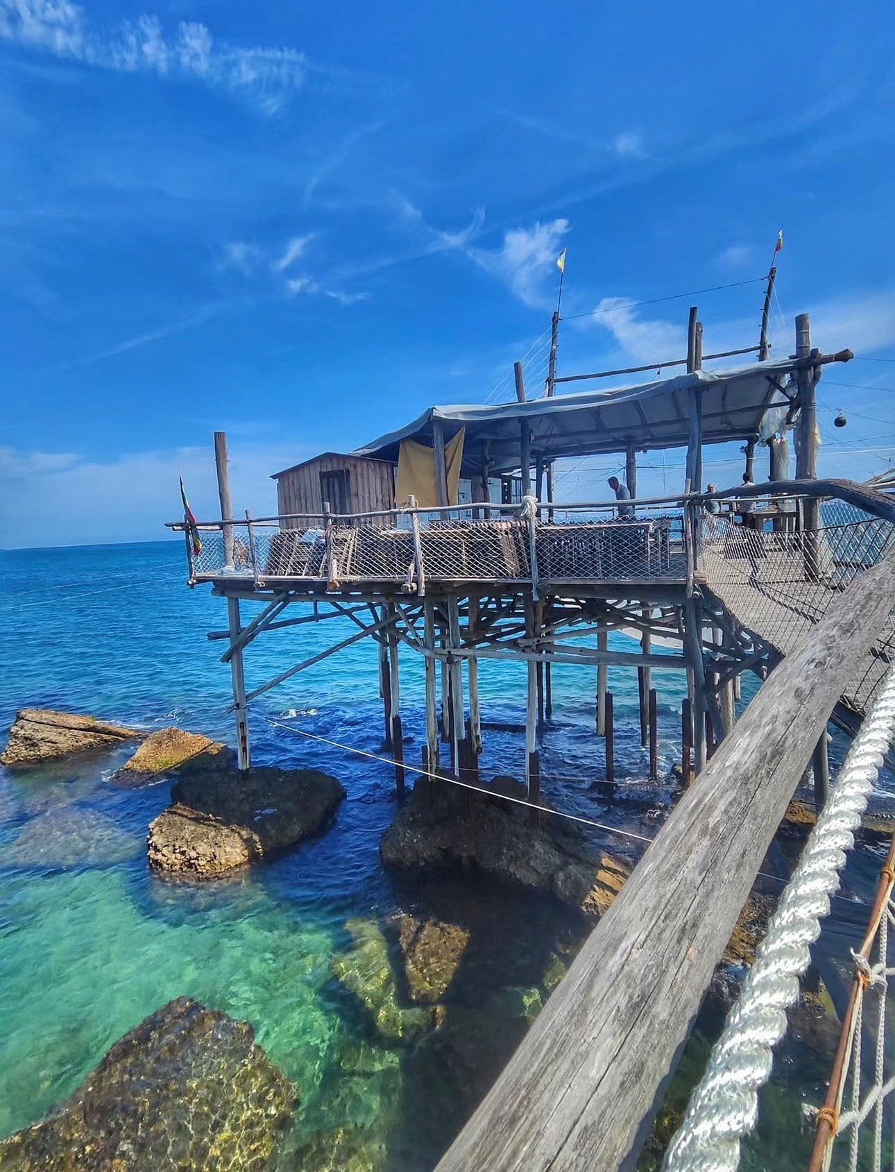 Wooden fishing trabocco extending over clear Adriatic water