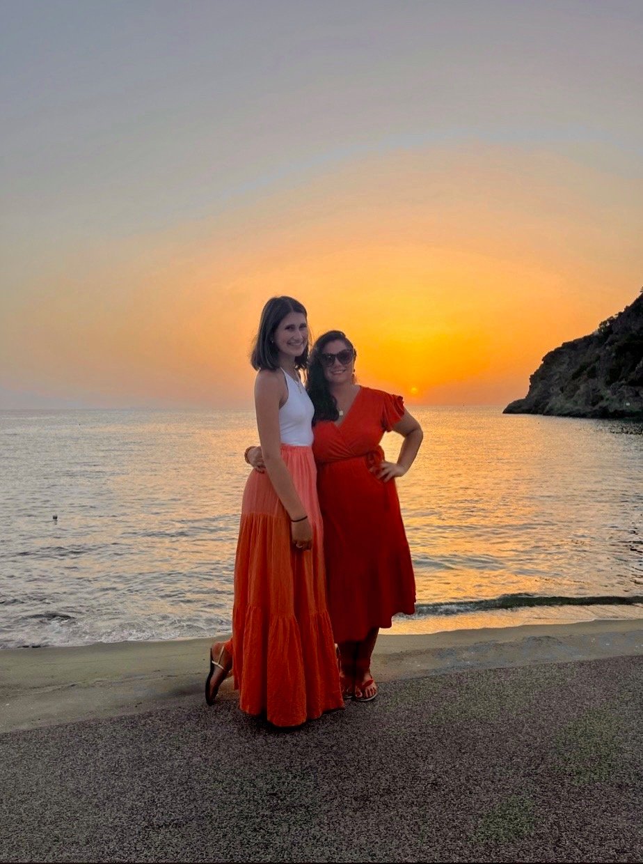 Tiffany and her daughter together by the sea at sunset on Ischia